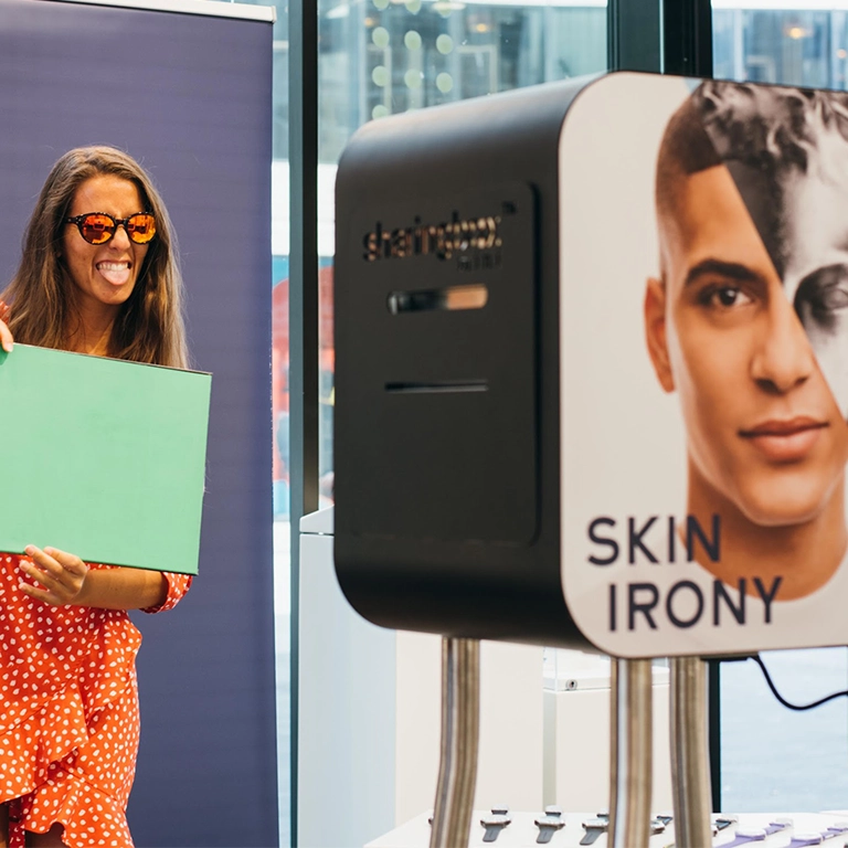 Woman using photobooth during Skin Irony event