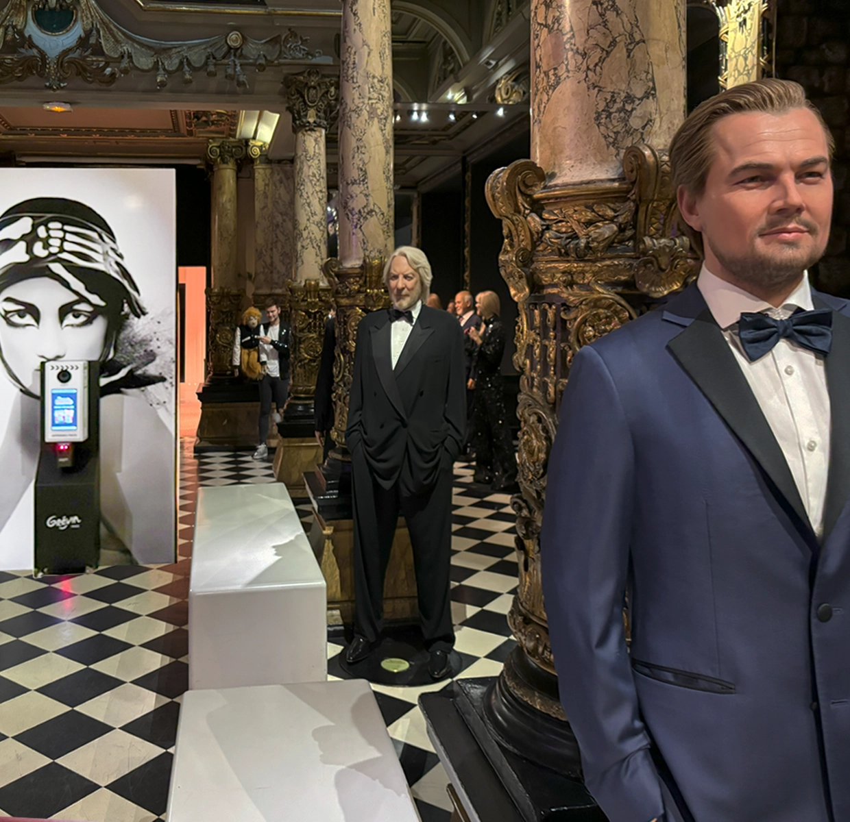 Enthusiastic guests pose alongside wax figures of iconic characters like Leonardo Dicaprio, immortalizing their visit to a popular entertainment attraction.