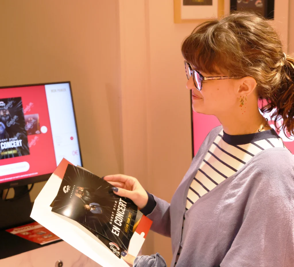 A guest looks at a photo album, reminiscing about their experiences at an immersive attraction, highlighting the personalized memories created