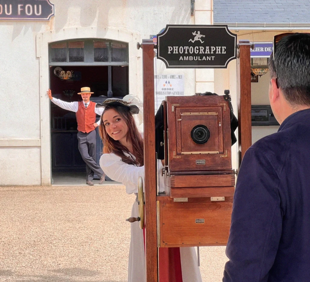 A guest posing for a photo with a period photographer at a traditional photo station in Puy du Fou
