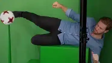 De man met het groene scherm gooit de bal.